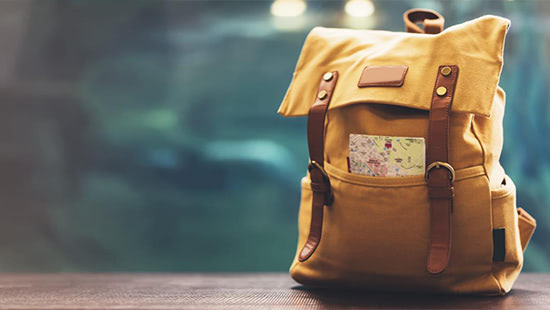yellow backpack with a book in it
