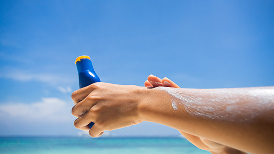 person applying sun cream on arm