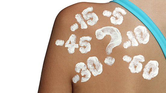 numbers of SPF written in sun cream on a woman's shoulder