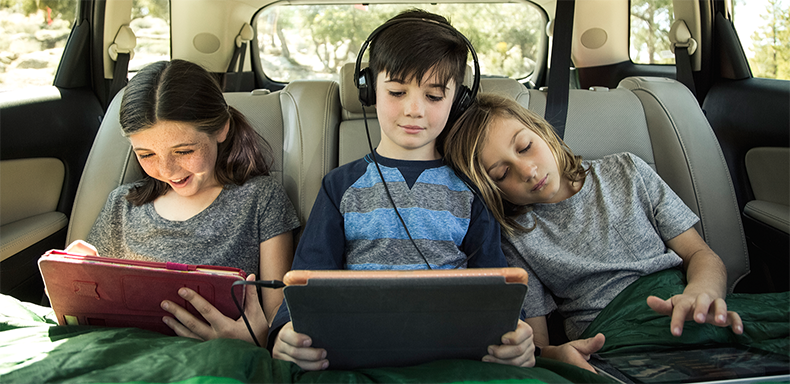 Three kids on ipad in back of the car